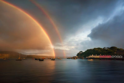 Scenic view of rainbow over sea against sky