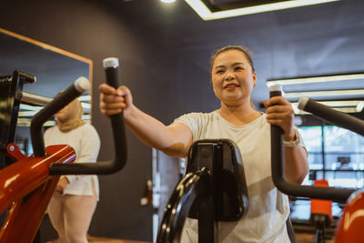 Young woman using mobile phone at gym