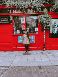 Full length of woman standing on footpath