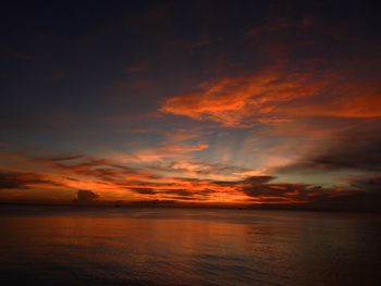 Scenic view of sea against dramatic sky during sunset