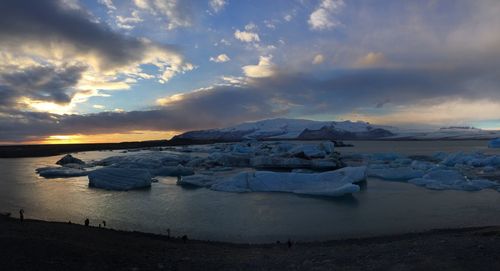 Scenic view of sea against dramatic sky during sunset