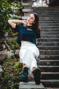 Portrait of beautiful young woman sitting on staircase