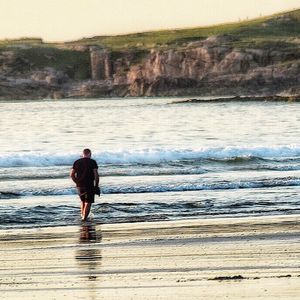 Rear view of man standing on beach