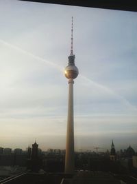 Silhouette of cityscape against cloudy sky