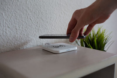 Smartphone being placed on wireless charging pad to charge battery