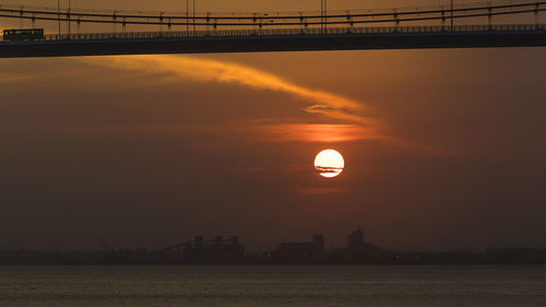 Scenic view of silhouette bridge against sky during sunset