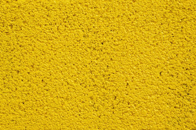 Painted yellow stone wall for texture background.