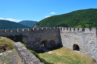 Stone wall with mountain range in the background. old castle in jajce, bosnia and herzegovina