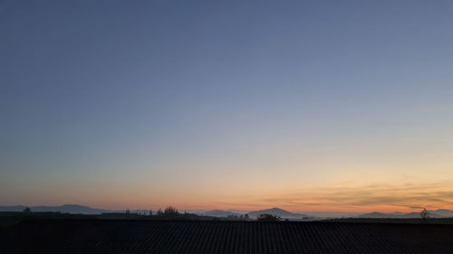 Scenic view of silhouette landscape against clear sky during sunset