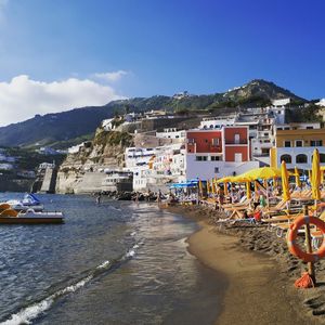 Scenic view of beach by buildings against sky