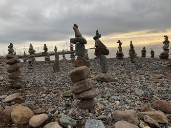 Stack of stones on beach against sky