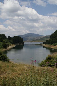 Scenic view of lake against cloudy sky