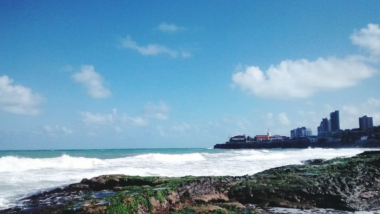 sea, water, sky, architecture, building exterior, built structure, horizon over water, scenics, cloud - sky, beauty in nature, beach, coastline, nature, cloud, shore, wave, rock - object, blue, tranquil scene, surf