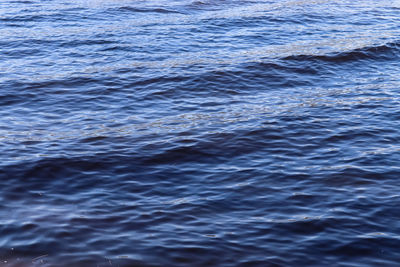 Detailed close up view on water surfaces with waves and ripples and the sunlight reflecting