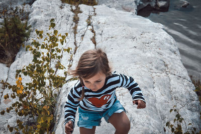 High angle view of boy standing on rock