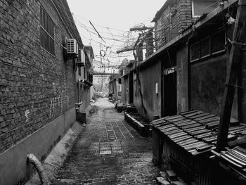 Footpath amidst houses against sky