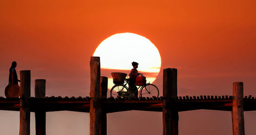 Silhouette men against clear sky during sunset