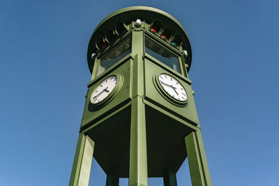 Low angle view of clock tower against clear blue sky