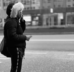 Full length of woman using smart phone on street