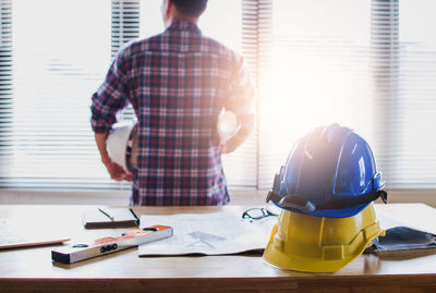 Rear view of man working on table