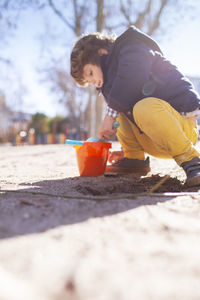 Rear view of boy playing on land