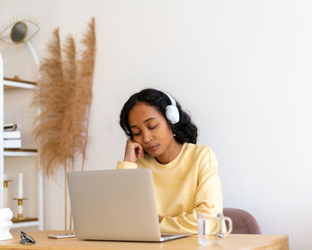 Young woman using laptop at table