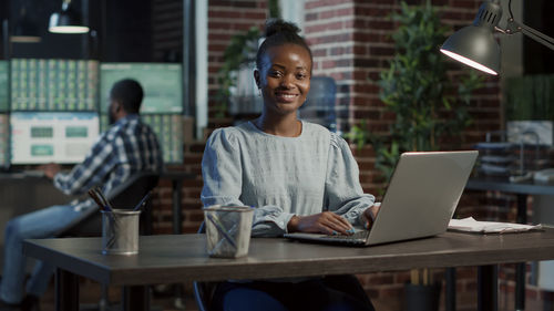 Portrait of young businesswoman using laptop at office