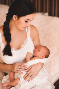 Young woman looking at her daughter in bedroom