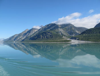 Scenic view of lake and mountains against blue sky