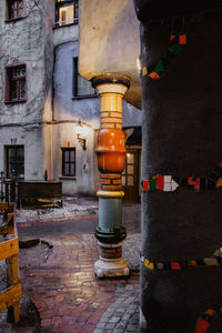 Illuminated street light by building at night