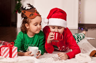 Cute sibling drinking hot chocolate at home
