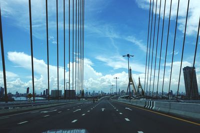 Cars on road in city against sky