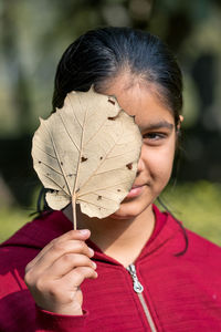 Close-up of woman holding leaf