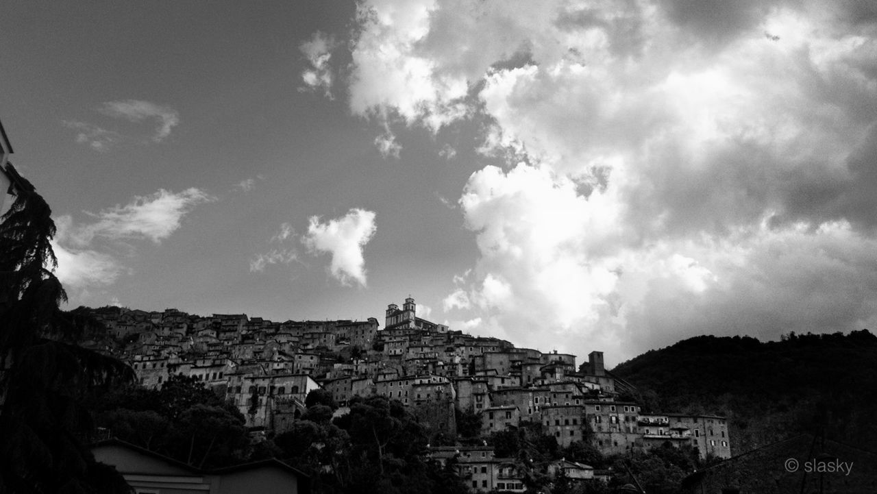 architecture, building exterior, built structure, sky, cloud - sky, cloudy, house, town, cloud, residential structure, mountain, tree, history, residential building, townscape, day, outdoors, low angle view, no people, nature