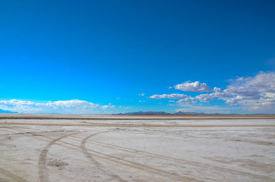 Scenic view of arid landscape against blue sky