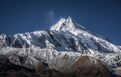 Low angle view of snowcapped mountain against sky