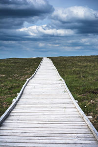 View of country road against cloudy sky