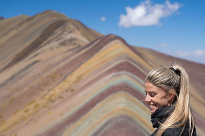 Young woman standing against mountain