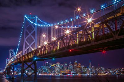 Suspension bridge over river at night