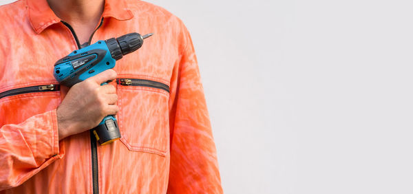 Midsection of woman holding umbrella against white background