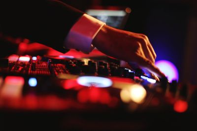 Close-up of hand on illuminated lighting equipment