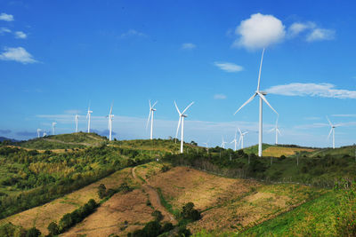 Windmills on field against sky