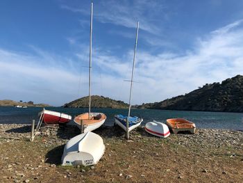 Boats moored on beach against sky