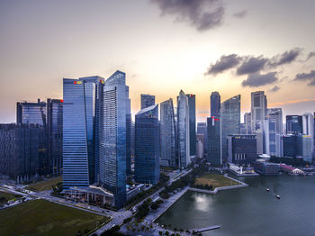 Modern buildings in city against sky during sunset