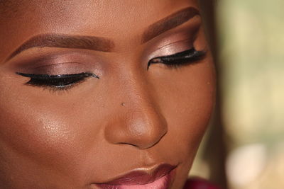 Close-up of woman wearing make-up at home