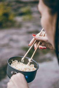 Cropped image of woman holding food in bowl