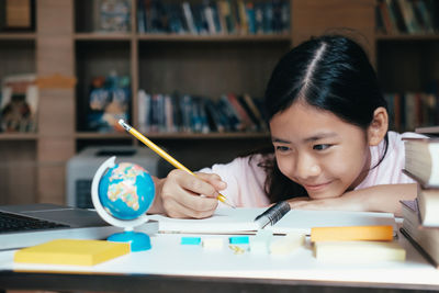 Close-up of teenage girl writing on book