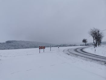 Scenic view of snow covered field against sky