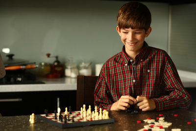 Children playing chess at home kitchen