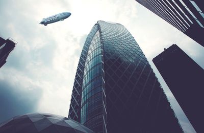 Low angle view of modern building against cloudy sky